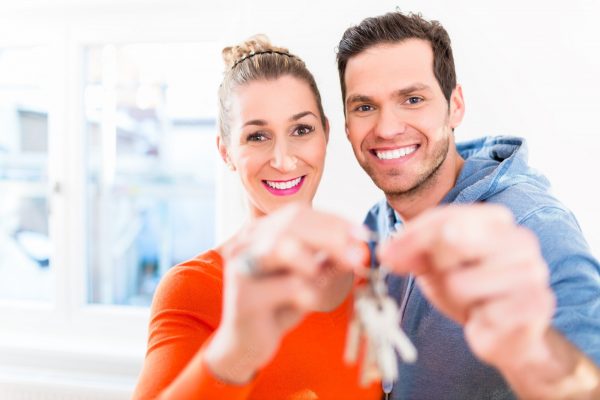 mulher-e-homem-segurando-com-orgulho-a-chave-da-casa-ou-da-casa_79405-13658